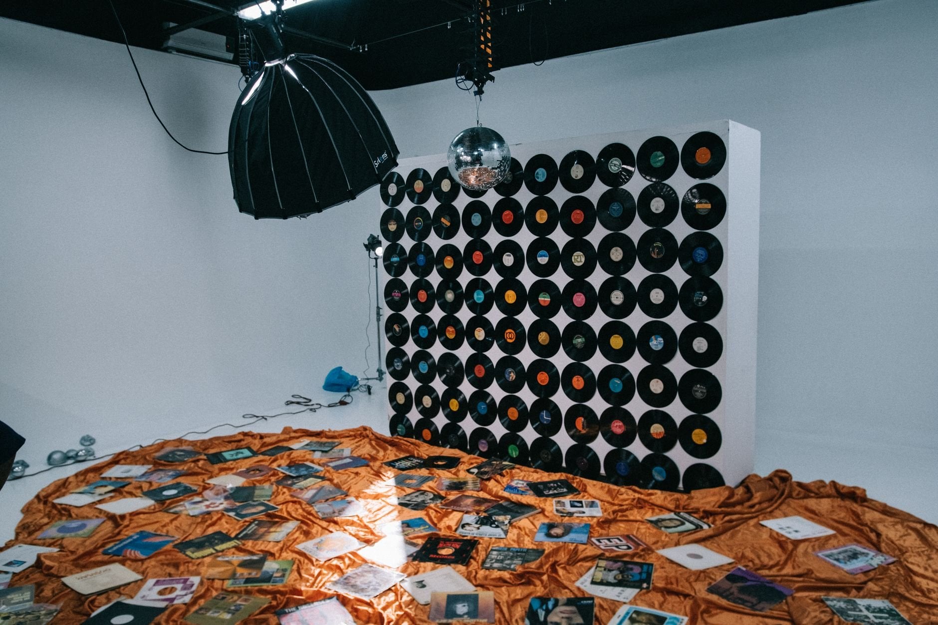 A creative studio setup showcasing a wall of vinyl records and soft lighting.